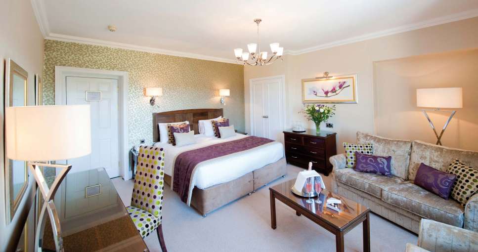 Imperial Hotel Accommodation Bedroom with Seating Area and Flutes of Champagne on Table
