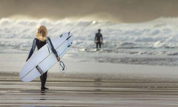 Lady with surfboard walking to sea 