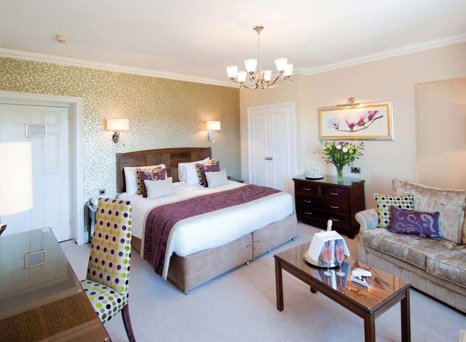 Imperial Hotel Accommodation Bedroom with Seating Area and Flutes of Champagne on Table