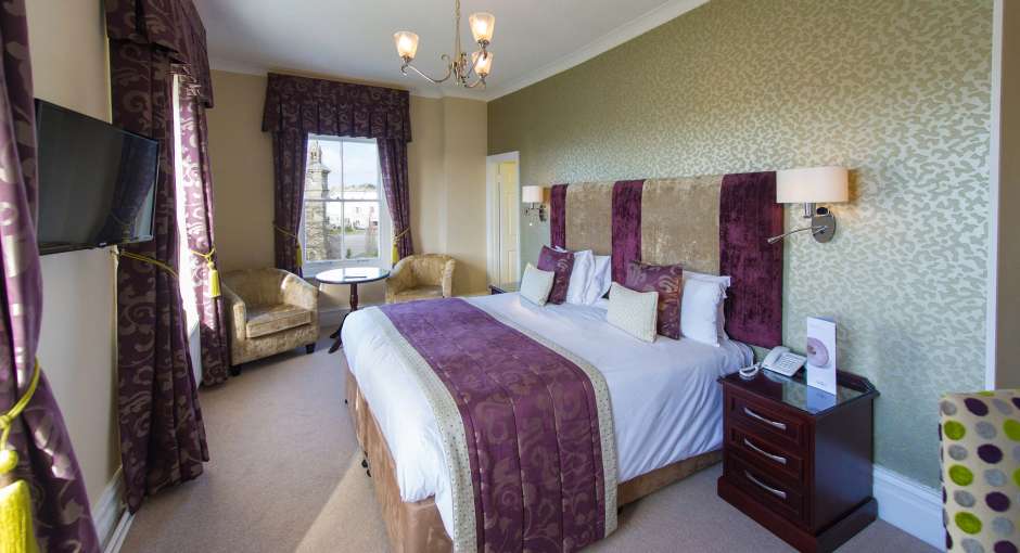 Imperial Hotel Accommodation Bedroom with Seating Area and Television