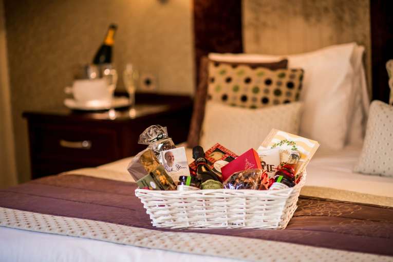 Imperial Hotel Festive Christmas Hamper on Bed in Room with Champagne