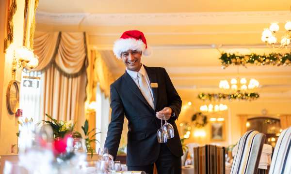 Sayed setting up table at Arlington Restaurant wearing a Christmas Hat