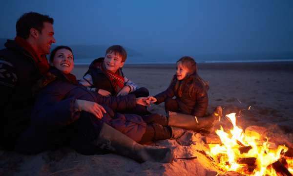 family on the beach with a bonfire