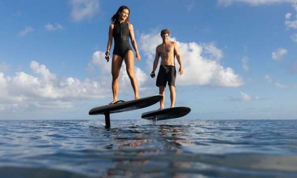 Two people stood on foil boards in the sea