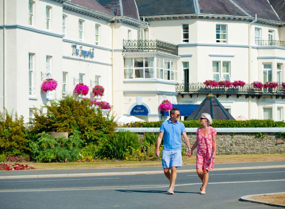 Imperial Hotel Couple Crossing Over Road in Front of Hotel