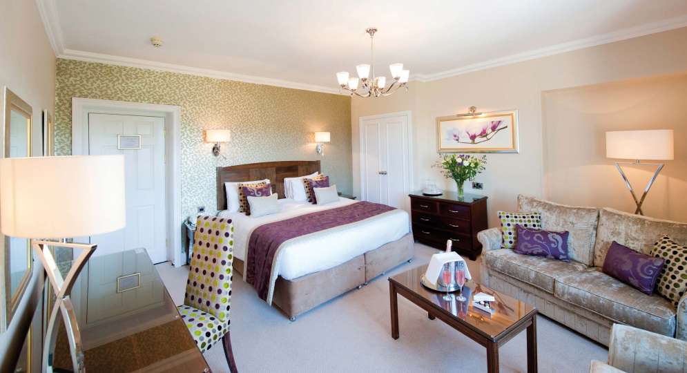 Imperial Hotel Accommodation Bedroom with Seating Area and Flutes of Champagne on Table